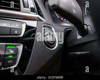 Derby, UK - August 14, 2025: close-up of a modern cars engine start/stop button, highlighting its sleek design and keyless ignition functionality with Stock Photo