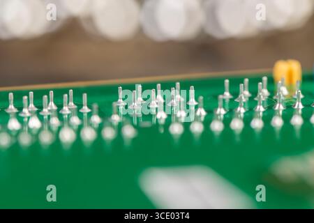 green circuit board with a large number of contacts, a simple green printed circuit board with an electronic circuit with soldered elements Stock Photo