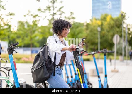 Woman activating electric scooter from smart phone Stock Photo