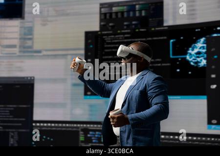 Digital tech expert coding and using VR headset at innovation hub, showcasing the intersection of data science and cybersecurity. Coding life immersed in high tech code development. Stock Photo