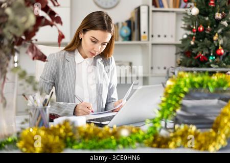 Woman working with documents during Christmas Stock Photo