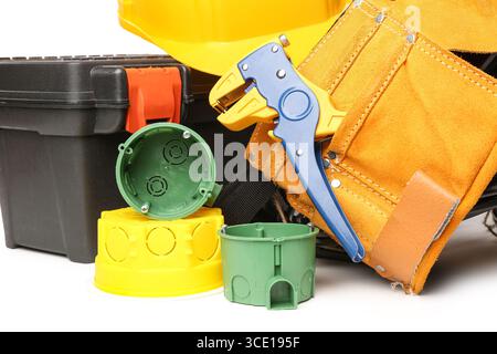 Electrician tools, rolled cables, electrical junction box and socket mounting boxes on white background Stock Photo