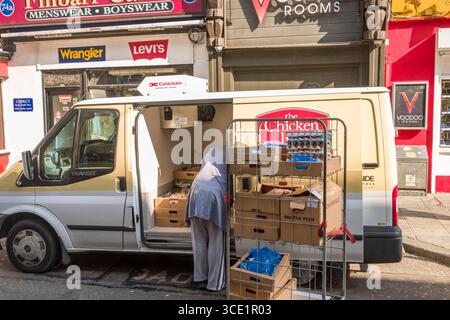 Man unloading cardboard boxes of poultry meat and eggs from a refrigerated delivery truck, Oliver Plunkett Street, Centre, Cork, County Cork Munster, Stock Photo