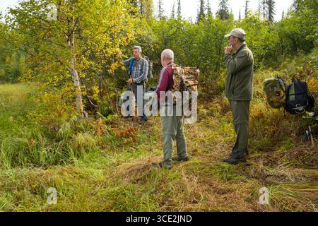Group of men standing on lakeshore of Miami Lake, Talkeetna Mountains, Matanuska-Susitna, Alaska, USA Stock Photo