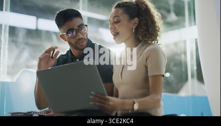 Laptop, happy and web developers in office with discussion for troubleshooting online problem solving. Computer, conversation and IT professionals Stock Photo