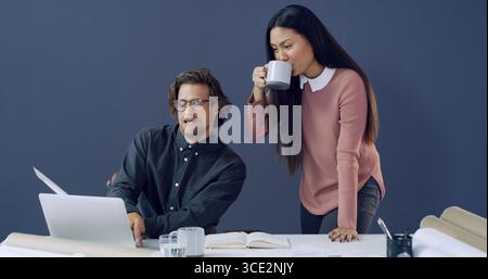 Coffee, laptop and architects with documents in office for city planning, email or meeting. Computer, cappuccino and construction designers with Stock Photo