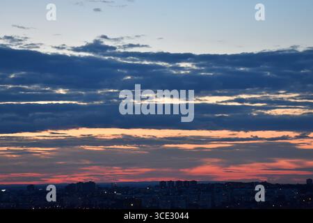 Urban skyline during magical twilight with vivid sunset colors and grayish clouds. Stock Photo