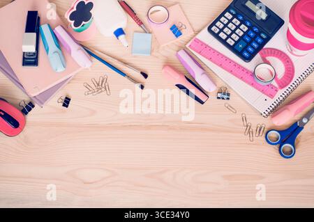on the wooden table there are notebooks, markers and various school supplies. Stock Photo