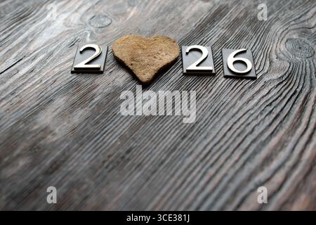 Happy New Year 2026 with cookie heart on  dark wooden background Stock Photo