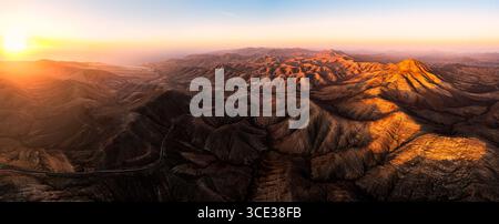 Aerial view of a desert landscape with rolling hills, sparse vegetation ...