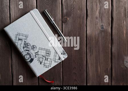 Flat lay composition featuring a stylish notebook and pen with an architectural theme, arranged on a weathered wooden surface. Perfect for concepts in Stock Photo