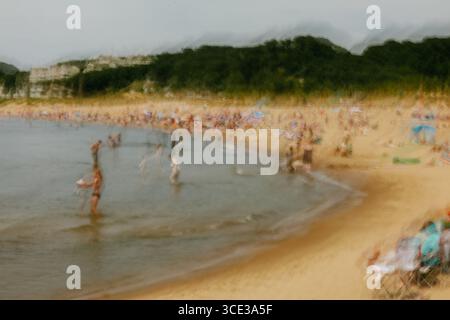 Abstract Motion Blur of a Busy Summer Beach Scene with People Stock Photo