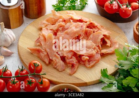 jerky on a wooden board with herbs, spices and vegetables Stock Photo