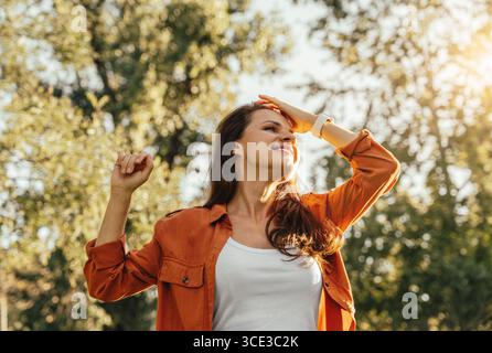 Low-angle portrait of happy young woman outdoors in early autumn Stock Photo
