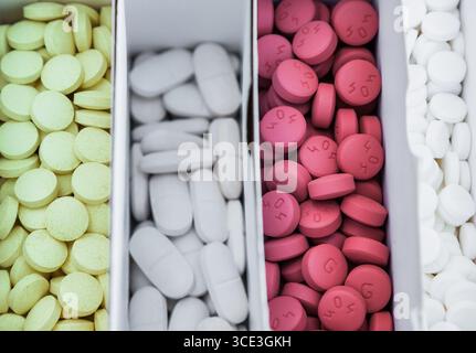 Four packages with multi-colored pills close-up. Stock Photo