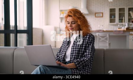 Smiling Caucasian woman female lady freelancer girl student e-learning working business online internet computer typing laptop internet shopping Stock Photo