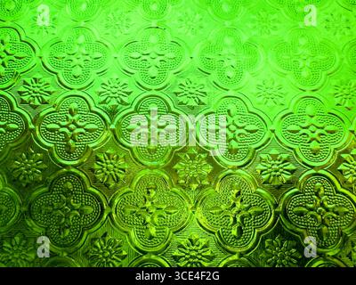 Close-up of textured green decorative glass with floral and geometric patterns creating a vintage stained glass effect. malaysia Stock Photo