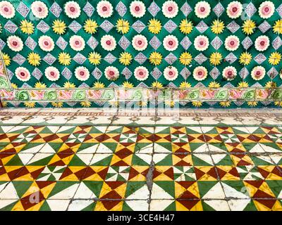 Colorful tiled floor and wall featuring vibrant geometric patterns and floral motifs in a traditional design Stock Photo