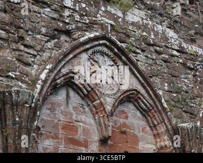 A detailed close-up of the highly decorative, carved sandstone arches and Gothic architecture at Furness Abbey Stock Photo