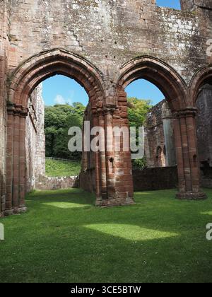 A detailed close-up of the highly decorative, carved sandstone arches and Gothic architecture at Furness Abbey Stock Photo
