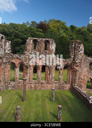 A detailed close-up of the highly decorative, carved sandstone arches and Gothic architecture at Furness Abbey Stock Photo