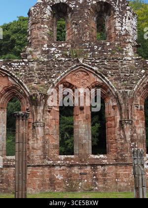 A detailed close-up of the highly decorative, carved sandstone arches and Gothic architecture at Furness Abbey Stock Photo