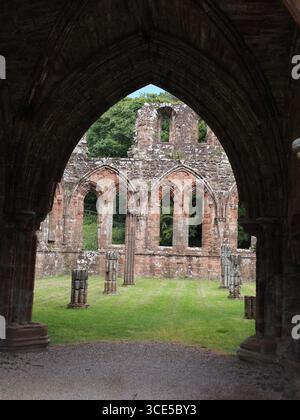 A detailed close-up of the highly decorative, carved sandstone arches and Gothic architecture at Furness Abbey Stock Photo