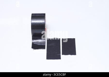 Black adhesive tape and pieces of black tape isolated on white background. Stock Photo