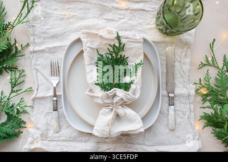 Plate setting with naturel linen napkins decorated for Christmas dinner Stock Photo