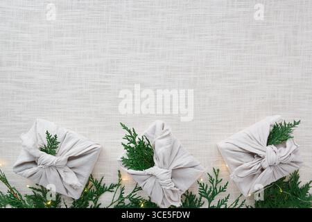 Fabric wrapped christmas gifts on linen background Stock Photo