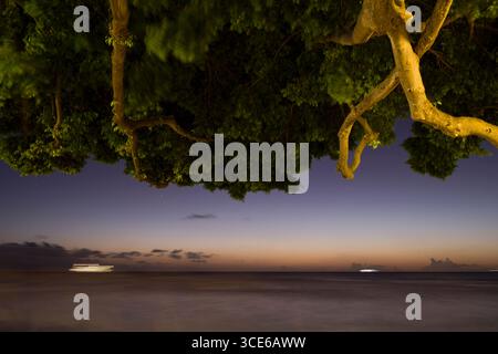 Light blurs of ships moving on the Pacific Ocean seen from Queen’s Beach, Waikiki, Honolulu, Oahu, Hawaii, USA Stock Photo