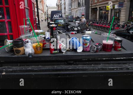 Discarded cups and aluminum cans on top of plastic trash bin, City of Westminster, London, England, United Kingdom Stock Photo