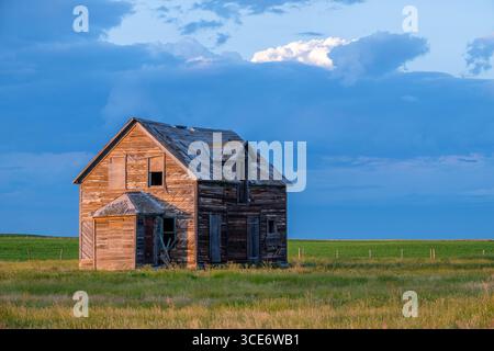 Dark storm clouds over an old, abandoned home on the prairies north of Rush Lake, Saskatchewan Stock Photo