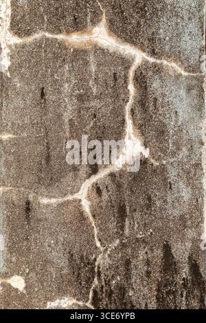 Close-up of cracked and weathered unpainted cement wall, front view. Abstract high resolution full frame textured background. Stock Photo