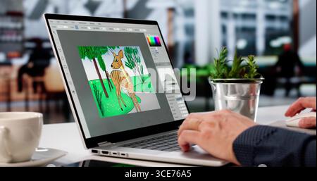 Young Caucasian Man Skillfully Edits Photos And Graphics On Computer. Stock Photo