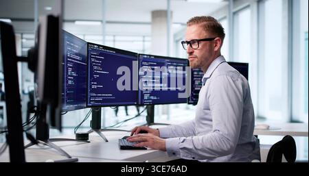 Male Software Engineer Coding At Office Computer Screen For Development. Stock Photo