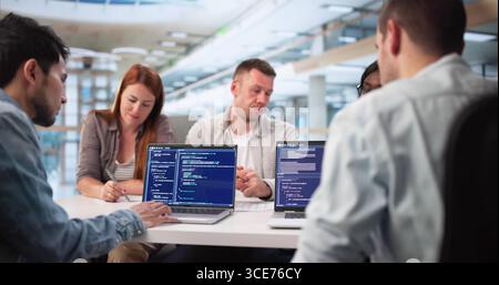Multiracial Software Engineers Collaborate On Coding Project For Tech Company Stock Photo
