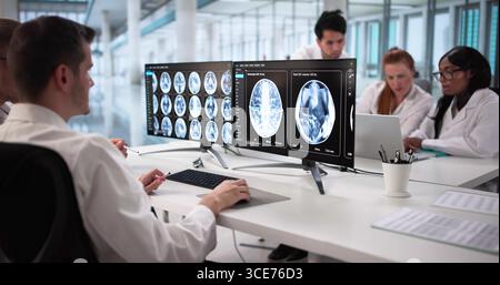 Medical Professionals Collaborating On MRI Brain Scans For Patient's Treatment. Stock Photo