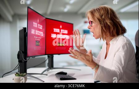 Senior Woman At Home Worried About Cyber Security Breach On Computer. Stock Photo