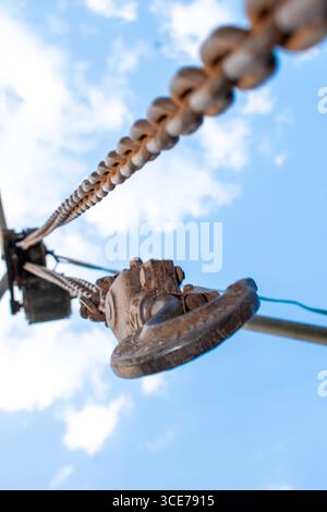Old rusty metal chain hanging, Rusty chain links outdoors in close up, detail of a chain and hook of a lifting winch Stock Photo
