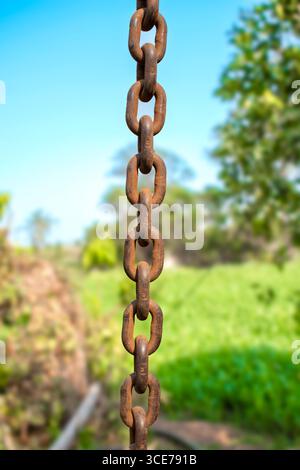 Old rusty metal chain hanging, Rusty chain links outdoors in close up, detail of a chain and hook of a lifting winch Stock Photo