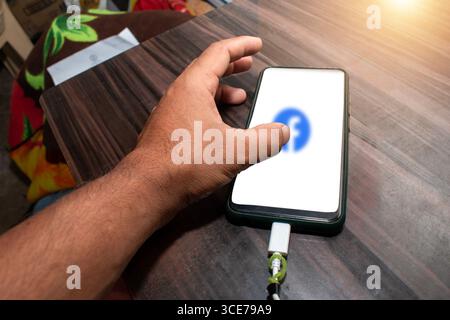 The mobile being used by the hand, The mobile is placed on the table Stock Photo