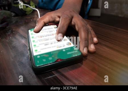 The mobile being used by the hand, The mobile is placed on the table Stock Photo