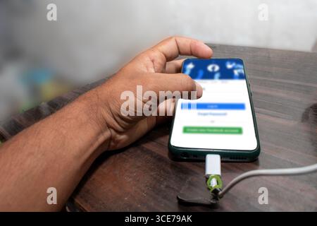 The mobile being used by the hand, The mobile is placed on the table Stock Photo