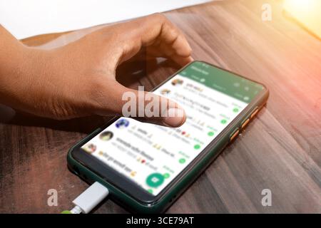 The mobile being used by the hand, The mobile is placed on the table Stock Photo