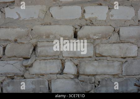 Construction, building materials, garbage, background of building bricks. Wall of white smooth brick with gray cement masonry, incorrect masonry. Stock Photo