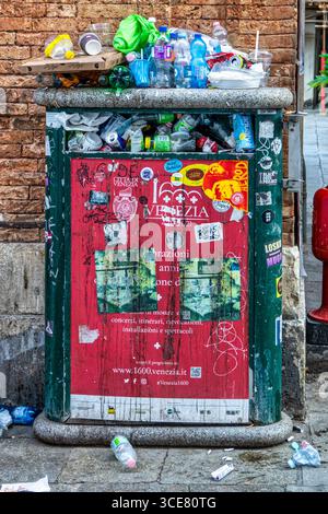 1 july 2025 Venice Italy.: overflowing public trash bin in Venice, Italy. The bin is full of plastic bottles, cans, food packaging, and other waste, w Stock Photo