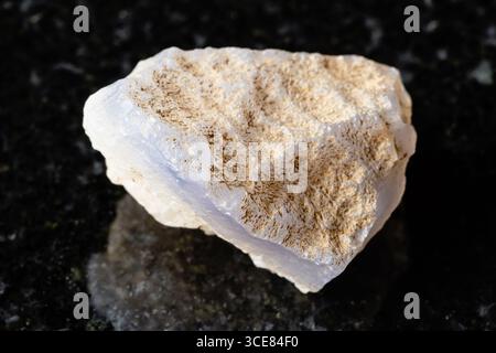 sample of raw blue agate mineral on black granite background close up from Uzbekistan Stock Photo