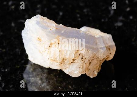 sample of rough blue agate rock on black granite background close up from Uzbekistan Stock Photo