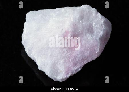 sample of raw pink aragonite mineral on black granite background close up Stock Photo